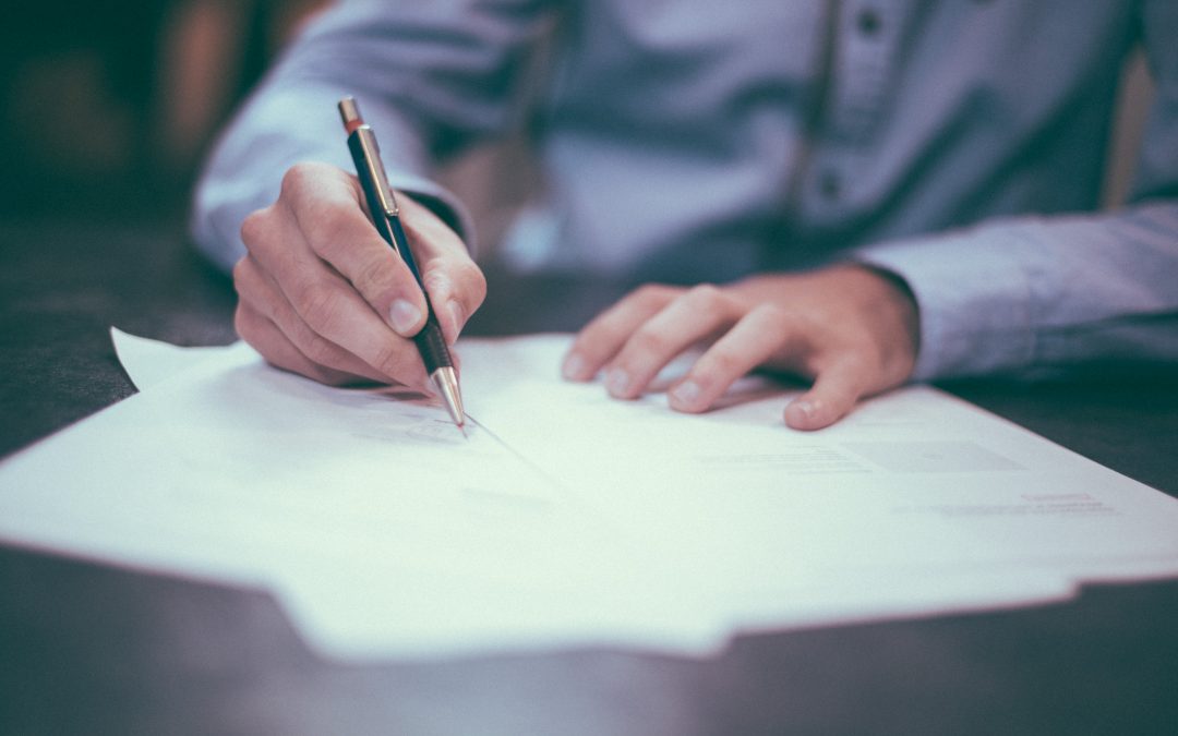 close up of a man signing an important document