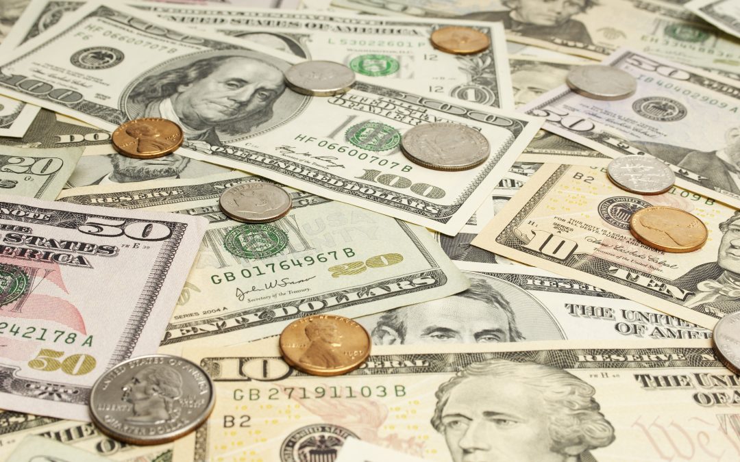 close up of a pile of american paper money and coins