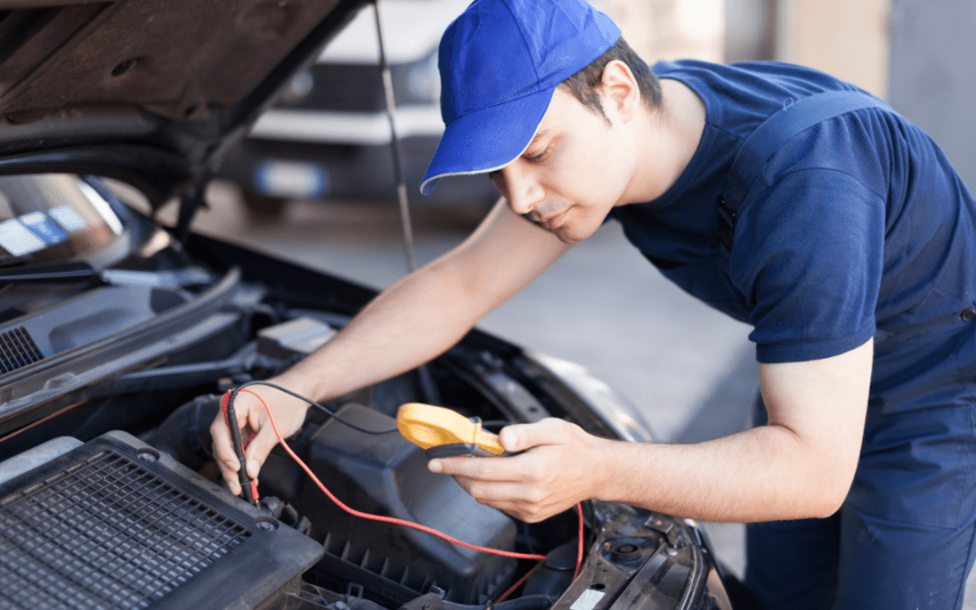mechanic using a computer to test an automobile