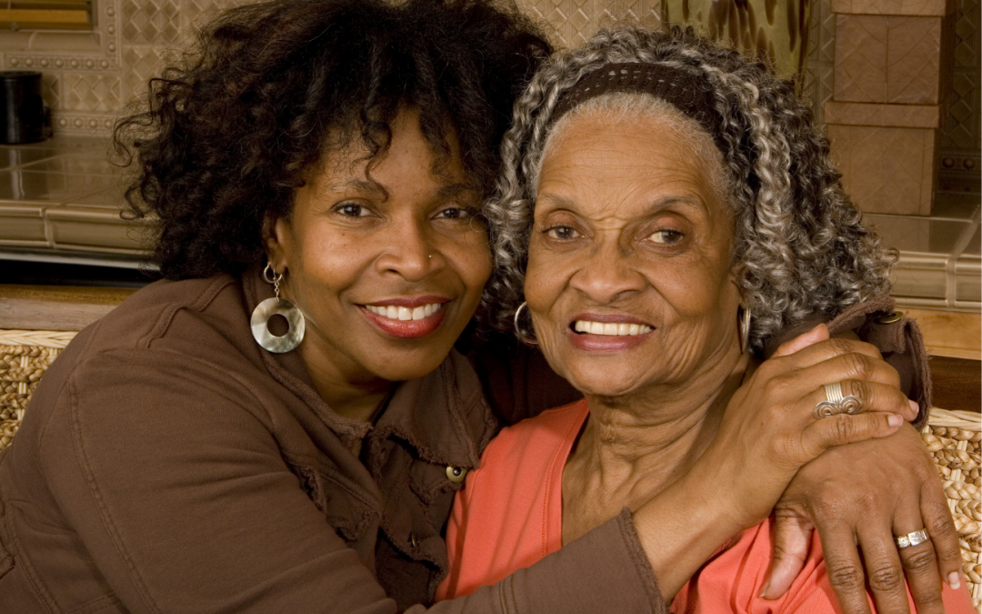 Close up of a daughter hugging her elderly mother while smiling. The daughter - Help aging parents avoid scams