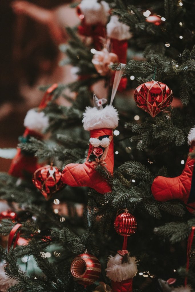 Close up of a Christmas tree with red quilted stockings. Holiday gift giving doesn't have to be wrapped up under a tree! 