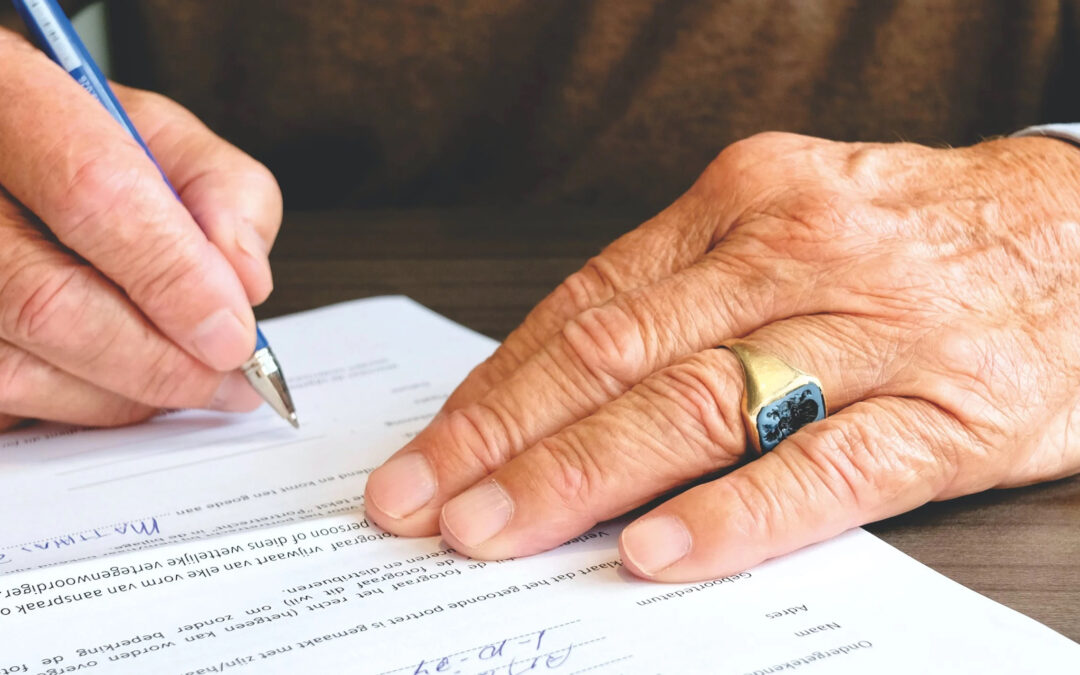 Closeup of two hands signing an application form.